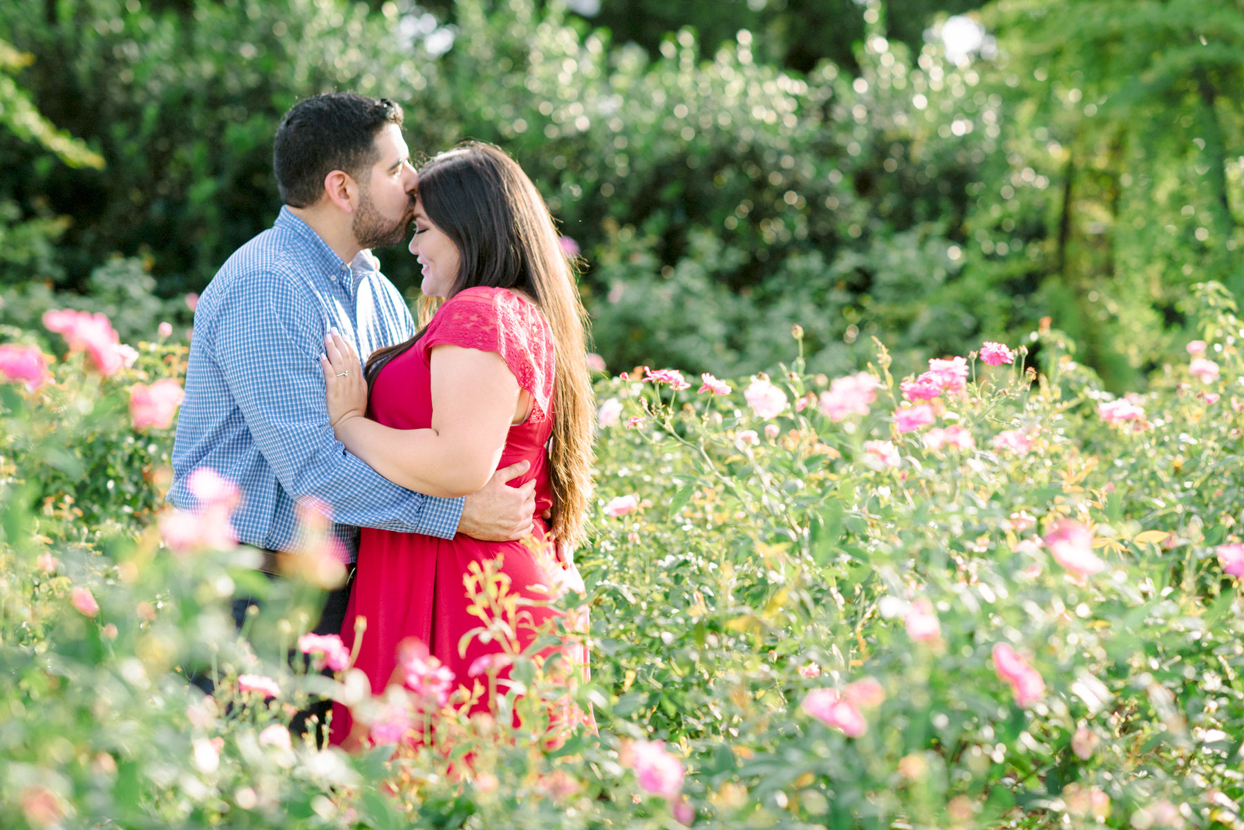 Gabe kissing Jessica on the forehead in a field of flowers